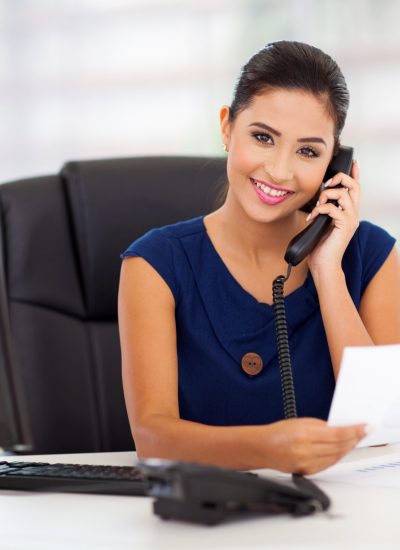 portrait of young secretary answering telephone